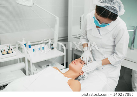 Beautician making injection against wrinkles in the female face Beautician making injection against wrinkles in the female face 140287895