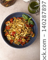 Noodles with shrimps, mussels, tomatoes, onions and capers. Pasta is served with olive oil and pesto sauce. Homemade traditional Mediterranean cuisine. Selective focus, close-up. 140287897