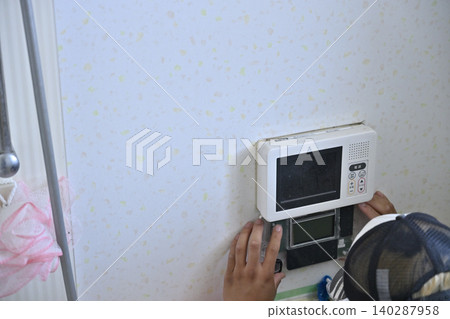 Installation of a remote control for an eco-friendly water heater (EcoCute) in the bathroom. Installation of a remote control for an eco-friendly water heater (EcoCute) in the bathroom. 140287958