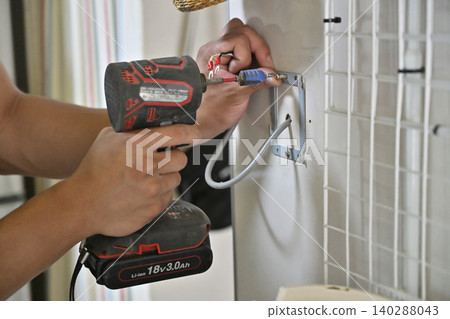 Installation of a remote control for an eco-friendly water heater (EcoCute) in the kitchen. 140288043