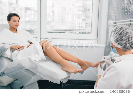 procedure of hardware manicure on women's legs. Chiropodist care about clients foot. procedure of hardware manicure on women's legs. Chiropodist care about clients foot. 140288086