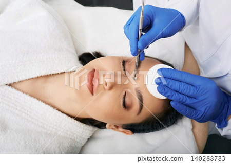 Cleansing face comedone spoon. Beautiful woman gets removal of comedones, blackheads, acne at a beauty clinic. View from above Cleansing face comedone spoon. Beautiful woman gets removal of comedones, blackheads, acne at a beauty clinic. View from above 140288783