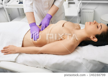 Medical exam. Doctor doing preventive check-up of a female abdomen for examination of woman's internal organs Medical exam. Doctor doing preventive check-up of a female abdomen for examination of woman's internal organs 140288799