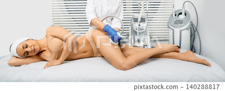 Hardware cosmetology. Ultrasound cavitation therapy. Beautiful woman having cavitation procedure to removing cellulite on legs and buttocks Hardware cosmetology. Ultrasound cavitation therapy. Beautiful woman having cavitation procedure to removing cellulite on legs and buttocks 140288817