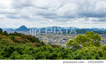 Panoramic view of Takamatsu city with cityscape, green hills, mountain ranges, and cloudy sky in Kagawa, Japan. 140288994