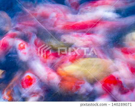 Motion-blurred colorful koi fish swimming in blue water abstract aquatic background. 140289071