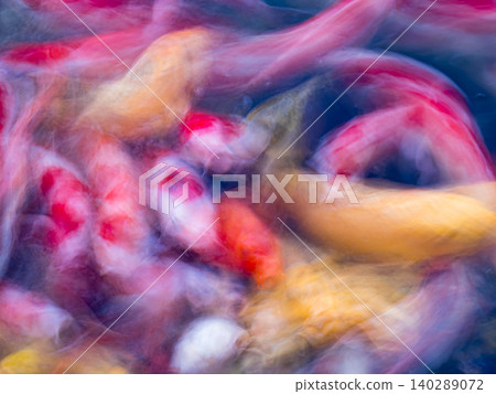 Motion-blurred colorful koi fish swimming in blue water abstract aquatic background. 140289072
