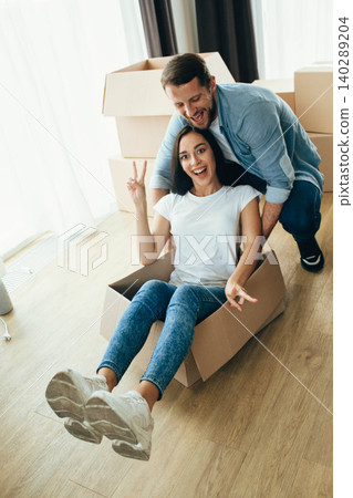Mixed race couple having fun with cardboard boxes while moving at new home. Mixed race couple having fun with cardboard boxes while moving at new home. 140289204