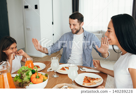 family, mother, father and daughter during dinner.Eating eating homemade pizza at home family, mother, father and daughter during dinner.Eating eating homemade pizza at home 140289228