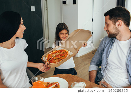 Family enjoying pizza lunch. Little girl having fun with her family Family enjoying pizza lunch. Little girl having fun with her family 140289235