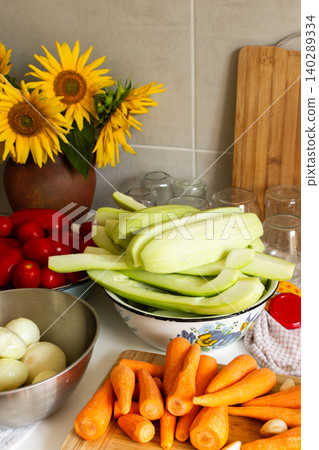 Fresh vegetables are arranged on a kitchen countertop for making squash caviar. Squash, carrots, tomatoes, and ingredients are prepared for winter canning Fresh vegetables are arranged on a kitchen countertop for making squash caviar. Squash, carrots, tomatoes, and ingredients are prepared for winter canning 140289334