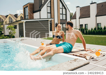 man and a woman look lovingly at each other while in the pool. Goodbye work, hi summer vacation-swimming and tanning man and a woman look lovingly at each other while in the pool. Goodbye work, hi summer vacation-swimming and tanning 140289413