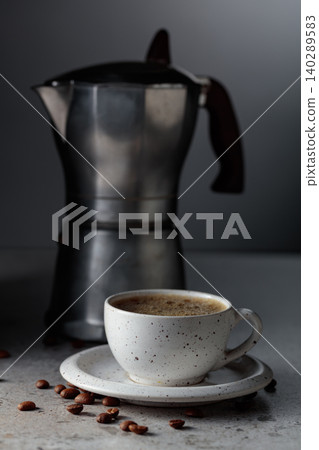 Cup of espresso and classic Italian aluminium moka pot on a gray stone table. Cup of espresso and classic Italian aluminium moka pot on a gray stone table. 140289583