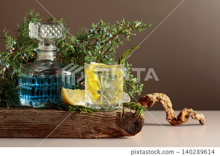 Cocktail gin-tonic with ice, lemon, and rosemary in a frozen glass. Cocktail gin-tonic with ice, lemon, and rosemary in a frozen glass. 140289614