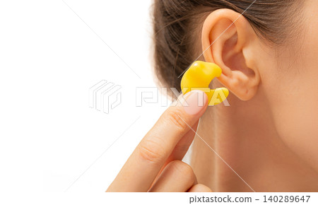 earplugs for noisy places, personally molded earplugs on ear close-up earplugs for noisy places, personally molded earplugs on ear close-up 140289647