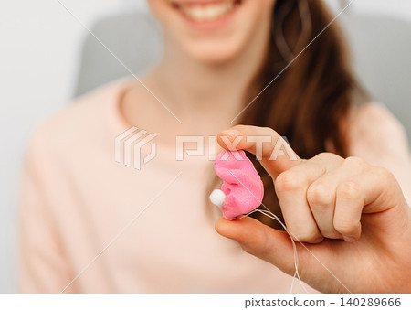 girl holding earplugs from an impression of an individual child ear. Earplug close-up. Personally molded earplugs. Part of the set girl holding earplugs from an impression of an individual child ear. Earplug close-up. Personally molded earplugs. Part of the set 140289666