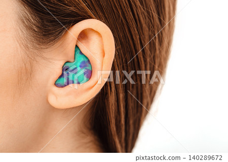 Personally molded earplugs for use in an airplane at high atmospheric pressure with pressure valve. Individual stylish earplugs close-up 140289672