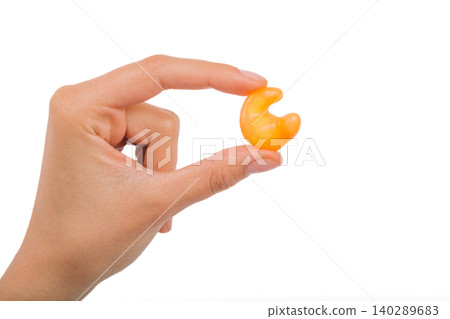 Isolated on white earplug in female hand. Personally molded earplugs close-up. Part of the set 140289683
