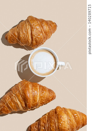 Cup of cappuccino coffee and croissants on a yellow isolated background Cup of cappuccino coffee and croissants on a yellow isolated background 140289715
