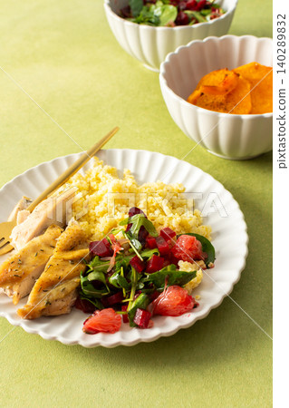 A balanced breakfast with millet, tender baked chicken breast, a refreshing salad of greens and grapefruit, and roasted sweet potatoes, offering a nutrient-packed meal A balanced breakfast with millet, tender baked chicken breast, a refreshing salad of greens and grapefruit, and roasted sweet potatoes, offering a nutrient-packed meal 140289832