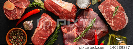 Various cuts of beef steak are shown with herbs, spices, and oil on a dark surface. Perfect for those looking to prepare or grill different beef dishes at home, banner Various cuts of beef steak are shown with herbs, spices, and oil on a dark surface. Perfect for those looking to prepare or grill different beef dishes at home, banner 140289887