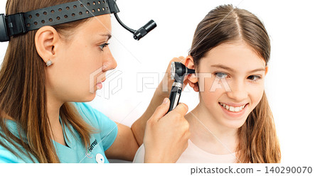 Girl patient getting ear exam at clinic, a doctor examining patient ear, using an otoscope Girl patient getting ear exam at clinic, a doctor examining patient ear, using an otoscope 140290070