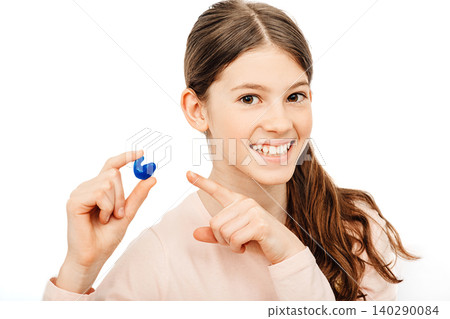 Advertising earplugs for children, a caucasian girl showing personally molded earplugs. Solution for noisy places Advertising earplugs for children, a caucasian girl showing personally molded earplugs. Solution for noisy places 140290084
