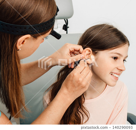 Hearing test. Positive girl in headphones during a hearing test, isolated on white. Audiometry Hearing test. Positive girl in headphones during a hearing test, isolated on white. Audiometry 140290093