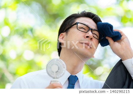Businessman, extreme heat, handheld fan Businessman, extreme heat, handheld fan 140290215
