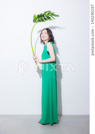 A woman holding a monstera leaf A woman holding a monstera leaf 140290287