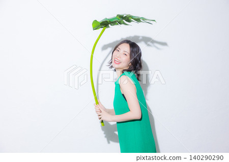 一位女子手捧一片龜背竹葉 一位女子手捧一片龜背竹葉 140290290