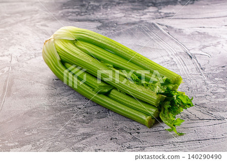 Fresh green celery stalks on grey textured background Fresh green celery stalks on grey textured background 140290490