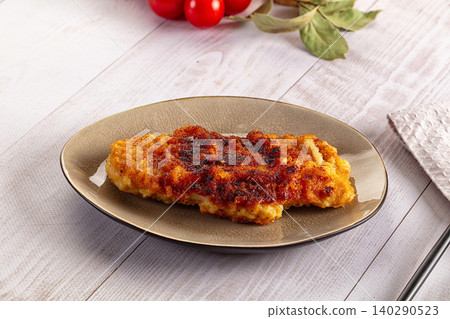 Crispy breaded chicken cutlet on ceramic plate with fresh tomatoes and herbs on white wooden table Crispy breaded chicken cutlet on ceramic plate with fresh tomatoes and herbs on white wooden table 140290523