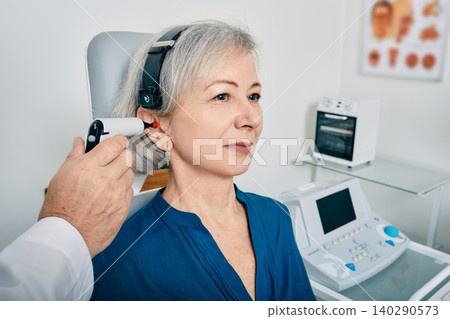 Elderly woman receives tympanometry with tympanometer probe at hearing clinic. Hearing check-up, impedance audiometry Elderly woman receives tympanometry with tympanometer probe at hearing clinic. Hearing check-up, impedance audiometry 140290573