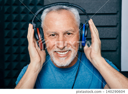 Hearing loss treatment. Positive senior man wearing audiometry headphones while hearing test and audiogram in special audio room 140290604