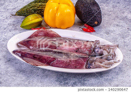 Fresh raw squid on white plate with vegetables 140290647