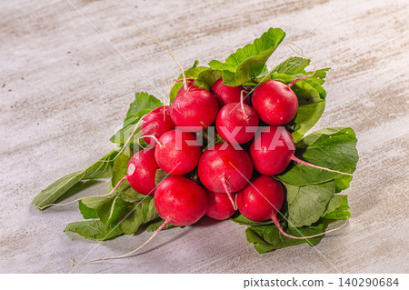 Fresh red radishes with green leaves on rustic wooden surface 140290684