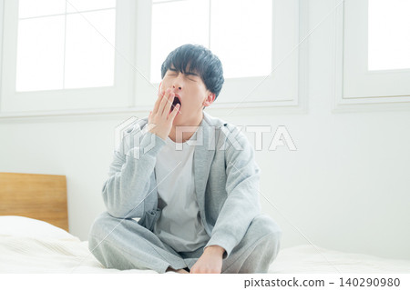 A man relaxing in the bedroom A man relaxing in the bedroom 140290980