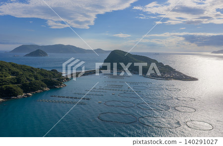 An aerial view of the coves and fish farms around Kashiwajima, Kochi Prefecture, illuminated by the evening light. An aerial view of the coves and fish farms around Kashiwajima, Kochi Prefecture, illuminated by the evening light. 140291027