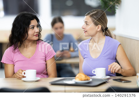 Latin girl are having nice conversation with female friend at cafe Latin girl are having nice conversation with female friend at cafe 140291376