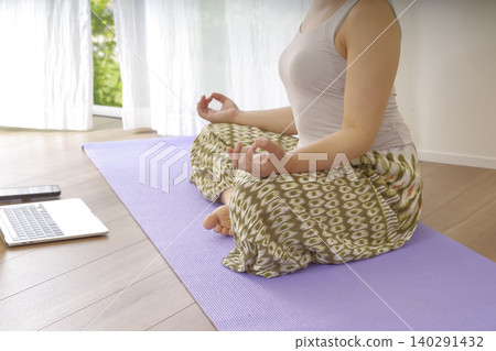 一位女性在冥想中平靜思緒時,雙手自然垂落。 一位女性在冥想中平靜思緒時,雙手自然垂落。 140291432