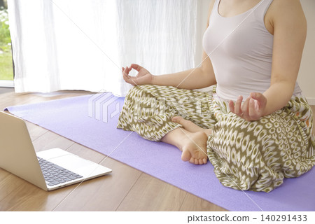 一位女性在冥想中平靜思緒時,雙手自然垂落。 一位女性在冥想中平靜思緒時,雙手自然垂落。 140291433