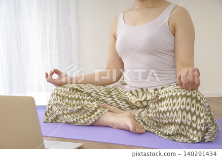 一位女性在冥想中平靜思緒時,雙手自然垂落。 一位女性在冥想中平靜思緒時,雙手自然垂落。 140291434