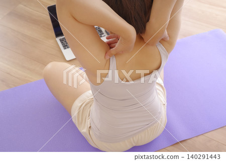 在家觀看瑜伽影片並練習瑜伽的女性。 在家觀看瑜伽影片並練習瑜伽的女性。 140291443
