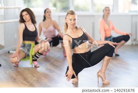 Woman with female perform dance in heels, squat down, actively repeat movements of instructor 140291676