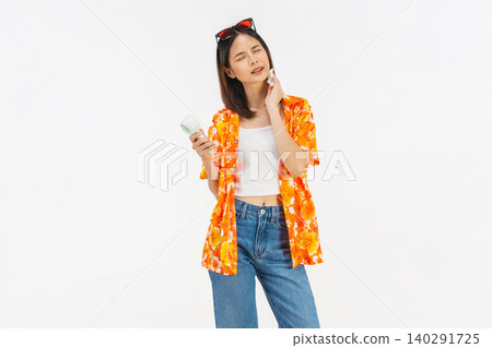 Young Asian woman in summer wearing floral shirt holding fan to cool herself with suffers from too hot weather in white background Young Asian woman in summer wearing floral shirt holding fan to cool herself with suffers from too hot weather in white background 140291725