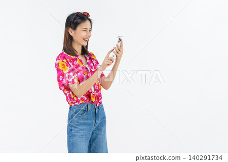 Portrait of young Asian woman in summer wearing floral shirt holding smartphone and smiling on white background. 140291734