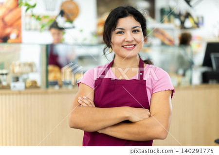 Latin female cafe employee greets guests of catering establishment Latin female cafe employee greets guests of catering establishment 140291775