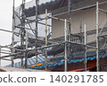 Scaffolding and netting for repairing house walls 140291785
