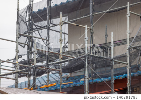 Scaffolding and netting for repairing house walls 140291785